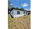 Shows exterior of house with white exterior and black roof with grass and trees at 3463 Fekany Pl, Orlando, FL 32805