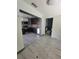 Kitchen with view to bathroom featuring stainless steel appliances, tile floors, and dark cabinetry at 3463 Fekany Pl, Orlando, FL 32805