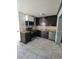 Kitchen with stainless steel appliances, tile floors, and dark cabinetry at 3463 Fekany Pl, Orlando, FL 32805