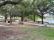 Picnic tables and a walking path near a lake in the community at 402 Ravenshill Way, Deland, FL 32724