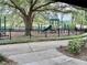 Community playground with green equipment and a lake in the background at 402 Ravenshill Way, Deland, FL 32724
