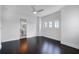 Bright bedroom with dark wood floors, ceiling fan, and ensuite bathroom, featuring natural light at 4065 Isabella Cir, Windermere, FL 34786