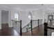 Bright hallway with dark wood floors, modern railing, and arched windows at 4065 Isabella Cir, Windermere, FL 34786