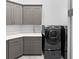 Well-equipped laundry room with gray cabinetry, counter space, and modern washer and dryer units at 4065 Isabella Cir, Windermere, FL 34786