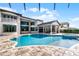 A luxurious backyard with an inviting pool, jacuzzi, covered patio, and meticulously designed outdoor living space at 4065 Isabella Cir, Windermere, FL 34786