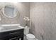 Elegant powder room featuring stylish wallpaper and a vessel sink with a decorative mirror at 4065 Isabella Cir, Windermere, FL 34786