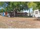 View of brick home exterior with a large tree in the dry, grassy backyard at 4279 Bomber Rd, Bartow, FL 33830