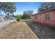 Spacious backyard featuring a brick home, chain-link fence, and mature trees under a bright, sunny sky at 4279 Bomber Rd, Bartow, FL 33830