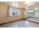 Bright living room featuring wood paneling, light tile flooring, and multiple windows offering natural light at 4279 Bomber Rd, Bartow, FL 33830