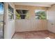 A full view of the patio featuring paneled walls, a concrete floor, and large windows at 4279 Bomber Rd, Bartow, FL 33830