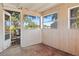 A full view of the patio with paneled walls, large windows, and an open doorway at 4279 Bomber Rd, Bartow, FL 33830