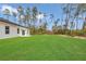 The spacious, well-manicured backyard shows the house and beautiful lawn with wooded backdrop at 4364 Sw 172Nd Street Rd, Ocala, FL 34473
