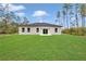 Home's rear elevation features a well-kept lawn and inviting double doors surrounded by large windows at 4364 Sw 172Nd Street Rd, Ocala, FL 34473