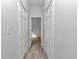 Hallway with wood-look floors, white walls, and access to rooms with closet space at 4364 Sw 172Nd Street Rd, Ocala, FL 34473