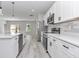 Elegant kitchen featuring white cabinets, stainless appliances, quartz counters, and wood-look flooring at 4364 Sw 172Nd Street Rd, Ocala, FL 34473