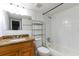 Bathroom featuring a granite-topped vanity, tiled shower, and storage shelving at 4727 S Texas Ave # 4727C, Orlando, FL 32839