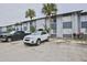 Exterior view of the light-blue apartment building with a parking lot with a white car and a black truck at 4749 S Texas Ave # 4749B, Orlando, FL 32839