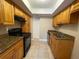 Kitchen with granite countertops, tile floor, black range/oven, and wooden cabinets at 4749 S Texas Ave # 4749B, Orlando, FL 32839