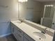 Stylish bathroom featuring a double sink vanity with quartz countertops, modern fixtures, and a glass-enclosed shower area at 5113 Prairie Preserve Run, St Cloud, FL 34772