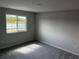 Cozy bedroom featuring a large window with peaceful water views, complemented by neutral walls and carpet flooring at 5113 Prairie Preserve Run, St Cloud, FL 34772
