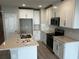 Bright kitchen featuring white cabinetry, quartz countertops, stainless steel appliances, and a central island with a sink at 5113 Prairie Preserve Run, St Cloud, FL 34772