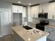 Modern kitchen with white cabinets, stainless steel appliances, quartz countertops, and a functional island, ready for cooking at 5113 Prairie Preserve Run, St Cloud, FL 34772