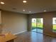 A spacious living room features wood-look tile flooring and sliding glass doors at 5113 Prairie Preserve Run, St Cloud, FL 34772