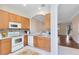 Open kitchen featuring white appliances and wooden cabinetry at 600 Northern Way # 1807, Winter Springs, FL 32708