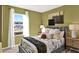 Cozy bedroom with large window, sheer white curtains, and stylish gray bed frame with decorative pillows at 797 Ambleside Dr, Haines City, FL 33844