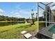 Backyard showcasing a serene lake view and access from the screened-in pool area at 80 White Marsh Cir, Orlando, FL 32824