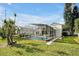 Large backyard featuring a screened-in pool, lush green lawn, and mature trees at 80 White Marsh Cir, Orlando, FL 32824