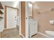 Convenient half-bath featuring a toilet and vanity sink adjacent to the laundry room at 80 White Marsh Cir, Orlando, FL 32824
