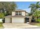Two-story home boasting a spacious three-car garage and lush tropical landscaping at 80 White Marsh Cir, Orlando, FL 32824