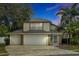 Two-story home boasting a spacious three-car garage and lush tropical landscaping at 80 White Marsh Cir, Orlando, FL 32824