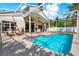 Enclosed pool area with a sparkling pool, patio seating, and screened enclosure at 80 White Marsh Cir, Orlando, FL 32824
