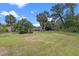 Expansive backyard with lush lawn, mature trees, and view of the sparkling pool at 820 Hobson St, Longwood, FL 32750