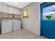 Bright laundry room with tile flooring, overhead cabinets, washer, and dryer at 820 Hobson St, Longwood, FL 32750