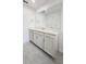 Bathroom vanity with a large mirror, white countertop, ample storage cabinets and tile flooring at 8563 Compass Point Ave, Orlando, FL 32832