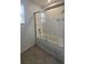 Bathroom featuring a white tiled shower-tub combination with glass doors and a chrome shower head at 8563 Compass Point Ave, Orlando, FL 32832