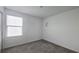 Cozy bedroom with a window, neutral carpet, white walls, and decorative moon and star wall accents at 8563 Compass Point Ave, Orlando, FL 32832