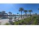 Community pool area with lounge chairs, umbrellas, palm trees, and a water slide at 8563 Compass Point Ave, Orlando, FL 32832