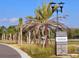 Entrance to Solstice community featuring a sign surrounded by palm trees and landscaping at 8563 Compass Point Ave, Orlando, FL 32832