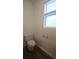 Bright powder room featuring a toilet and small window at 8563 Compass Point Ave, Orlando, FL 32832