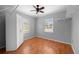 Neutral bedroom with hardwood floors, ceiling fan, white wardrobe, and dual windows for great natural light at 1010 Timor Ave, Orlando, FL 32804