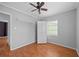Bedroom with hardwood floors, ceiling fan, white wardrobe, and single window to the exterior at 1010 Timor Ave, Orlando, FL 32804