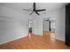 Bedroom with wood laminate flooring, white walls, mirrored closet doors, and ceiling fan at 1010 Timor Ave, Orlando, FL 32804
