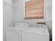 The room highlights laundry appliances, overhead shelving, and a window with blinds at 1010 Timor Ave, Orlando, FL 32804