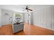 Bright living room featuring wood laminate flooring, ceiling fan, and large windows for abundant natural light at 1010 Timor Ave, Orlando, FL 32804