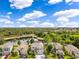 A neighborhood view showcases a light-blue, two-story home with beautiful pond views at 10142 Hidden Dunes Ln, Orlando, FL 32832