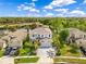 Beautiful, two-story light-blue home with palm trees, a brick driveway, and a pond view at 10142 Hidden Dunes Ln, Orlando, FL 32832